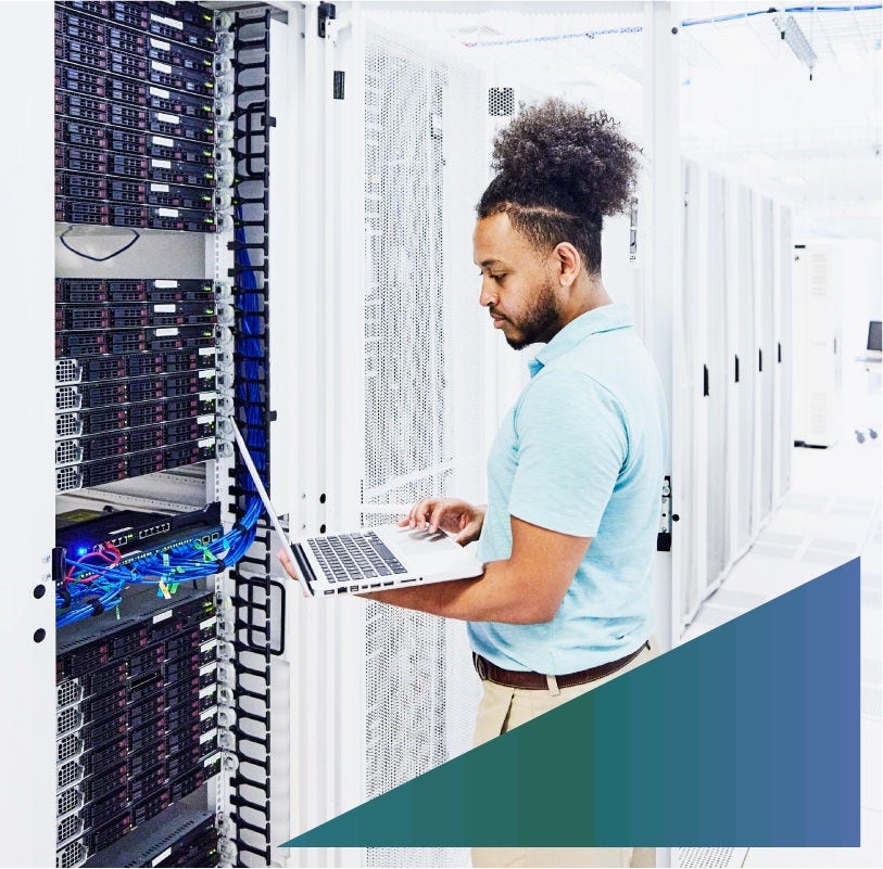 IT employee diagnoses server equipment in a server room.